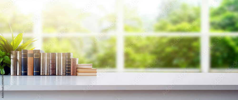 Poster Stack of books on white table with window view of green nature background