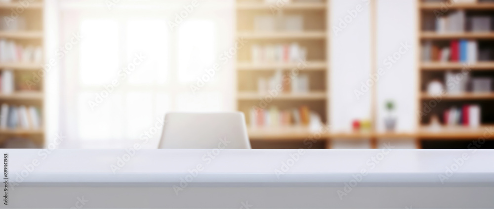Poster Empty white desk with chair in a blurred library background, ideal for displaying your products