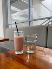 A glass of water and a glass of iced chocolate on the table.