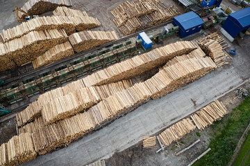 Sawmill with chopped wood logs stacked and machinery
