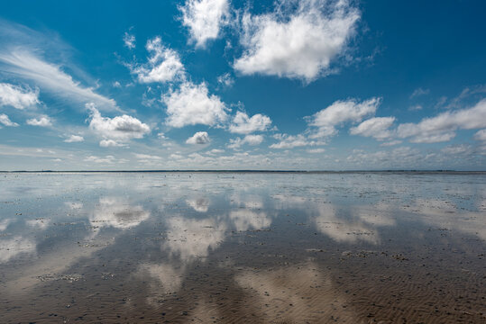 Ebbe am Wattenmeer an der deutschen Nordseek&uuml;ste bei sch&ouml;nem Wetter und aufgelockerter Bew&ouml;lkung, die sich im Waser spiegelt