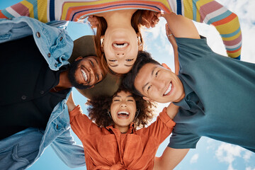 Friends, huddle and portrait in outdoor hug, solidarity and low angle for love on blue sky. People, social diversity and embrace for support or reunion, together and youth culture for motivation