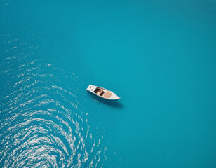 Naklejka premium Aerial View of a Boat in Turquoise Water with Circular Ripples