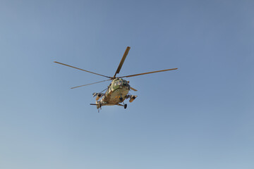 Military Helicopter in Flight Against Clear Blue Sky