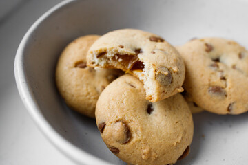 American Twix soft cookies with chocolate and caramel drops in white bowl