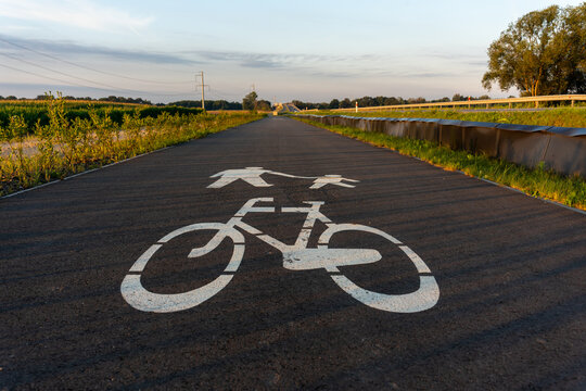 Bicycle and pedestrian path marking on countryside road at sunset. Concept of outdoor activities, healthy lifestyle, and road safety. High quality photo