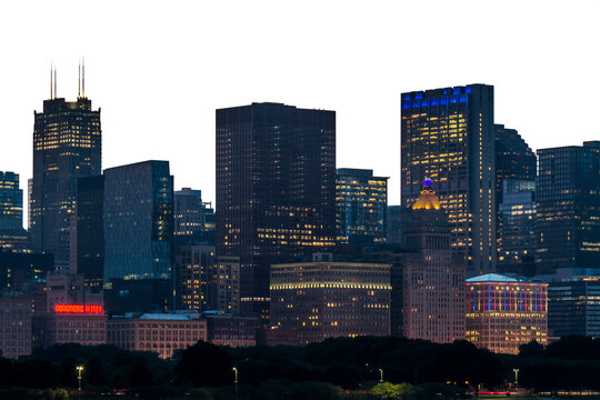 Chicago skyline at night with illuminated buildings against a white backdrop, showcasing the city's architectural beauty. Urban cityscape concept