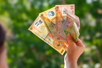 Fan of Romanian Lei banknotes in hand