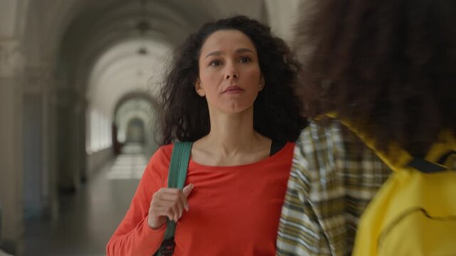 Hispanic student girl woman female lady walking going in university college academy hall corridor to lesson class group of aggressive student push hit shoulder pushing bully bullying in high school