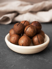 macadamia nuts on a white plate on a dark background