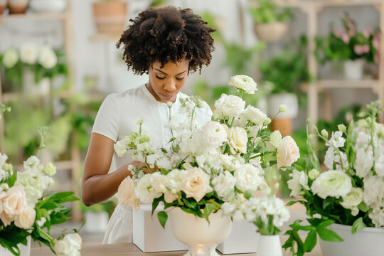 An African American woman florist prepares a beautiful wedding bouquet