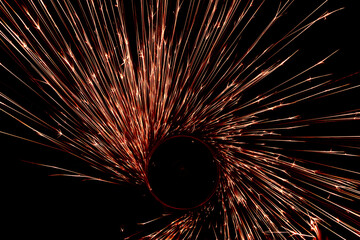 red sparks from the grinder glowing in the dark