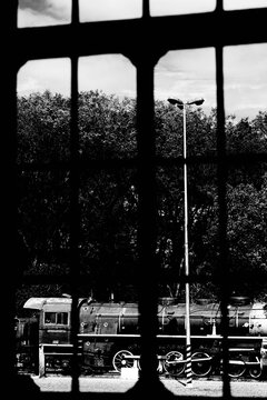 Trem parado em um p&aacute;tio em preto e branco. 