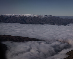 Aerial view of mountain covered by clouds.