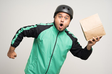 Young asian rider wearing green jacket uniform and bike helmet various action holding food paper bag delivery to customer. Male delivery service worker. Courier and shipping food service.