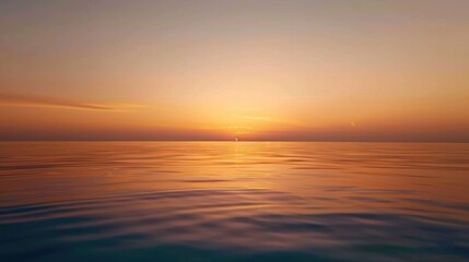 Obraz premium Golden sunset over calm ocean waters with soft hues and reflections, creating a peaceful and serene coastal scene.
