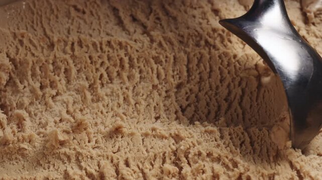 Slow motion closeup hazelnut praline ice cream scooping