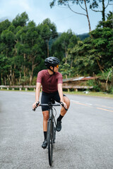 A young woman riding her bicycle in the mountains.
