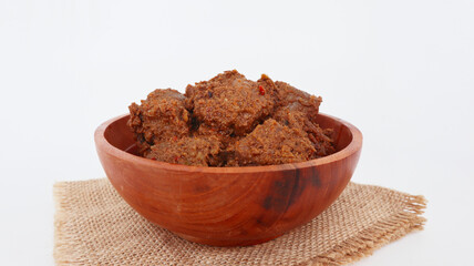 Rendang Padang. Spicy beef stew from Padang, Indonesia. The dish is arranged among the spices and herbs used in the recipe. isolated on white background