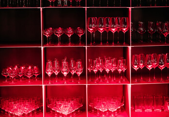 Shelf with Numerous Glasses Illuminated by Red Light