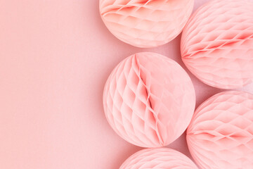 Tissue paper balls on a pink glittering background. Creative concept with copy space.