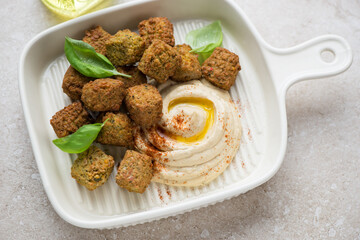 Beige serving tray with hummus and falafel, horizontal shot, selective focus