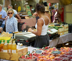 People looking at goods at the Uzès market, one of the most beautiful in France