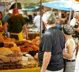 People looking at goods at the Uzès market, one of the most beautiful in France
