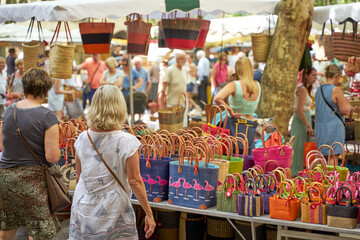 People looking at goods at the Uzès market, one of the most beautiful in France