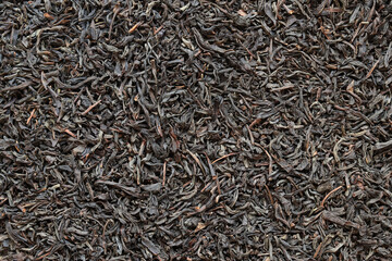 Long black tea, texture. Top view of dried tea leaves. Tea composition. Ingredients for a hot...