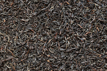 Long black tea, texture. Top view of dried tea leaves. Tea composition. Ingredients for a hot...