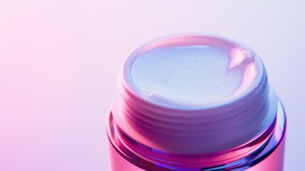 Open pink jar of face cream showing its texture illuminated by a pink and blue light