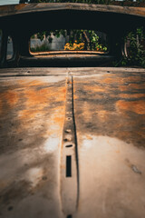 Vintage rusty hood of an old American car. Windows of the vehicle without glass.