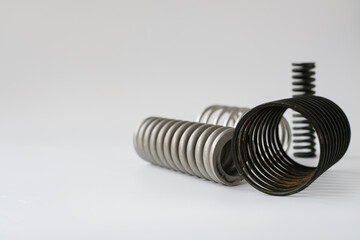 Set metal springs of different metals. Spare parts of the engineering industry. White background. Copy space. 