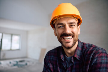 Portrait of happy worker at construction site looking at camera.