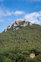 Scenic vertical summer view of ancient medieval Puilaurens cathar castle ruin on rocky mountain, Lapradelle-Puilaurens, Aude, France