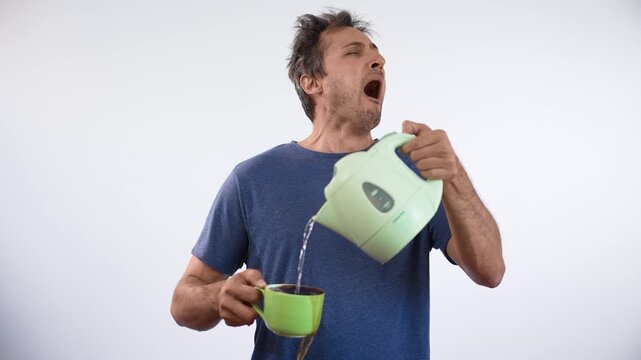 Man pours boiling water into cup while yawning