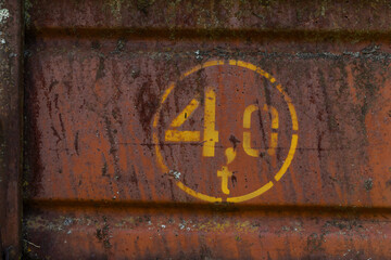 rusty metal plate or sign with number 4 (four) tons