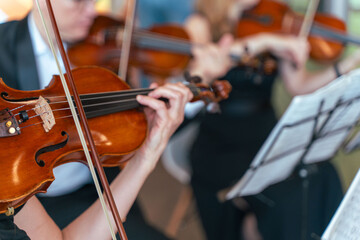 Professional symphony orchestra performing on stage and playing classical music concert, violinist...