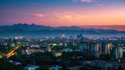 Fototapeta premium An expansive view of Almaty's cityscape at dusk with vibrant lights and mountains visible.