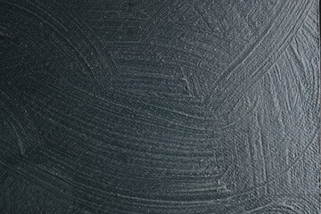 Parete con texture materica a rilievo dipinta di colore grigio-verde; spazio per testo
