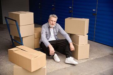 Male sitting and resting in storehouse after work