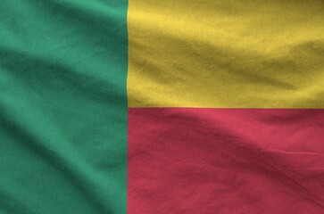 Benin flag depicted on folded wavy fabric of old cloth close up