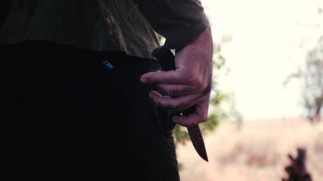  The killer waits for his victim with a knife in his bloody hand. 