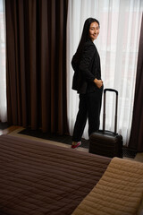 Attractive Asian woman check in hotel and enjoying view from window