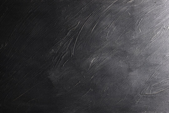 Superficie con texture materica molto irregolare dipinta di colore grigio-nero; spazio per testo