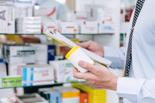 Pharmacist Manual Checking Pharmacy Inventory In Drugstore. Medicine Shop Staff Check Drug Expiration Name List.