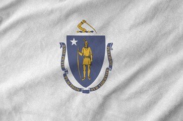 Massachusetts US state flag depicted on folded wavy fabric of old cloth close up