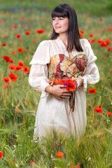 Young medieval woman in love with a basket in a flower meadow