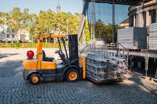 Yellow Heavy Load Forklift Truck Transporting Stage Equipment to the Event
